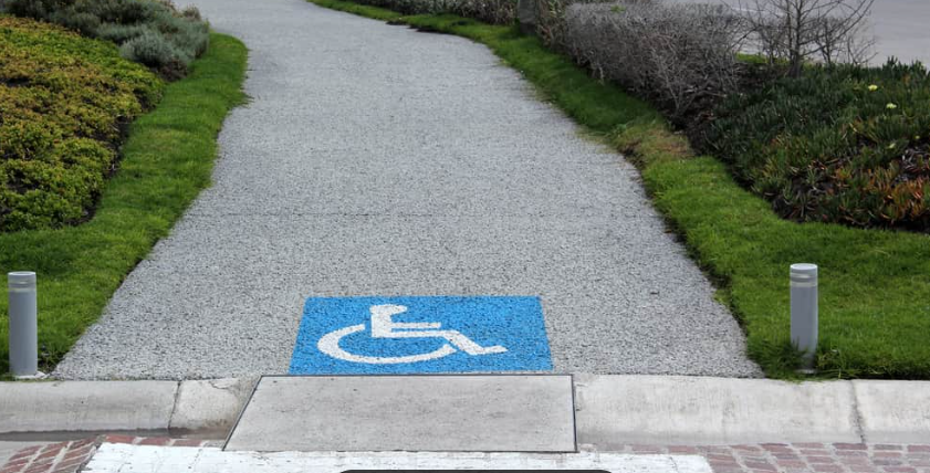 A person using a wheelchair boarding an accessible transit van by ramp